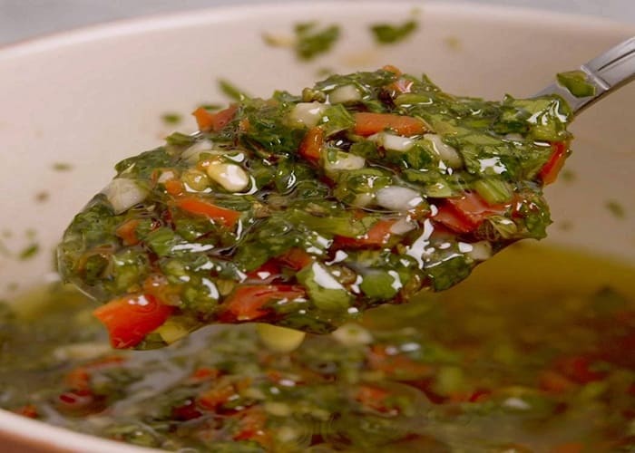 Chimichurri argentino en frasco de vidrio con hierbas frescas y especias
