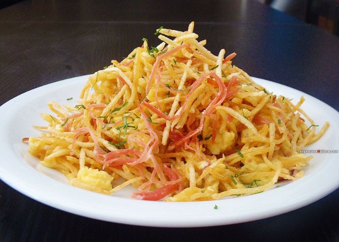 Revuelto gramajo con jamón, arvejas y hilos de papa crocantes
