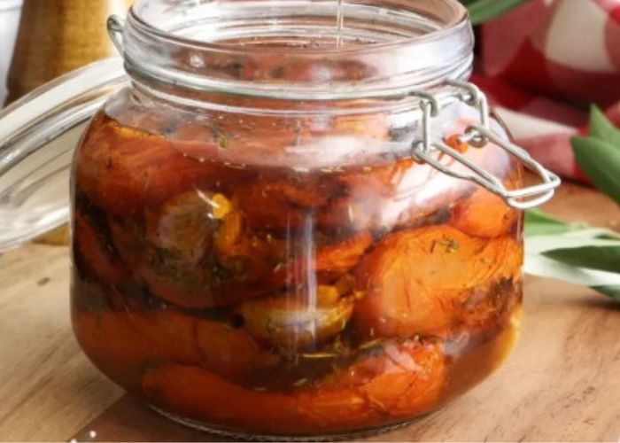 Tomates cherry y ajos dorados sumergidos en aceite de oliva virgen extra