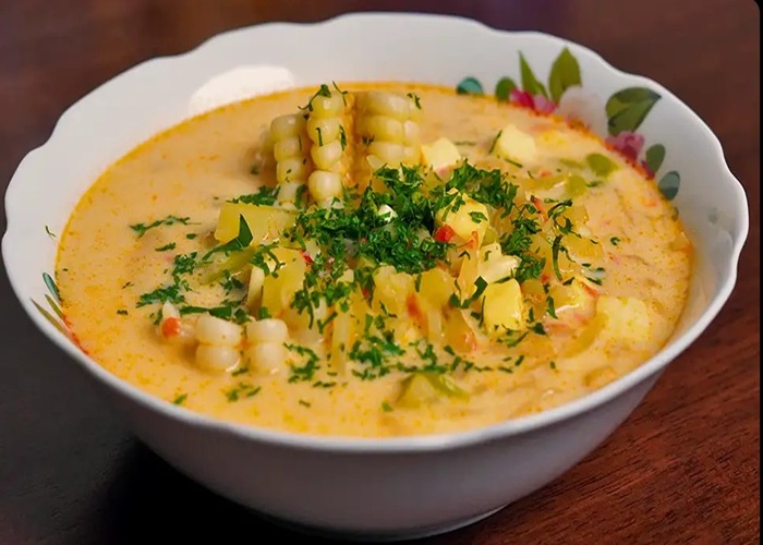 Guiso de olluco amarillo con cubos de queso fresco y hierbas