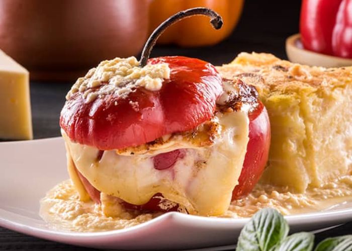 Rocotos rellenos gratinados servidos en plato de barro