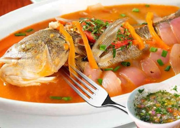 Filete de pescado sudado con tomates y cebollas en su jugo