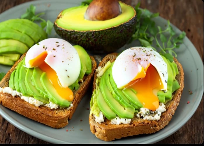 Tostadas de pan integral con palta machacada y huevo poché
